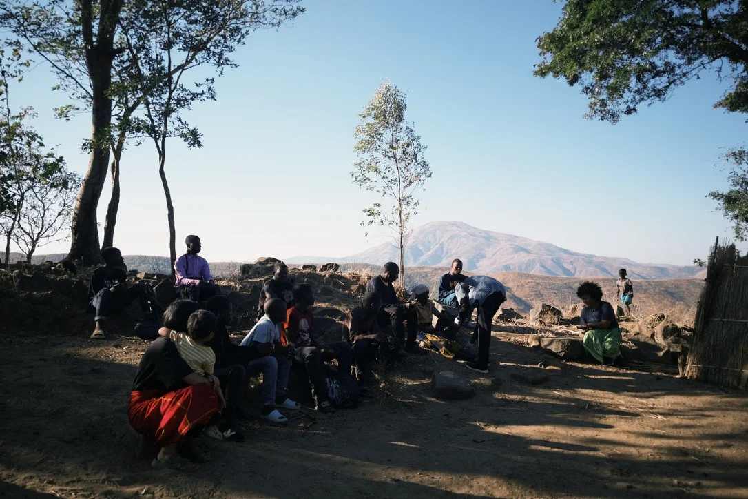 Jovens e adolescentes sentados observando o cuidado de um idoso