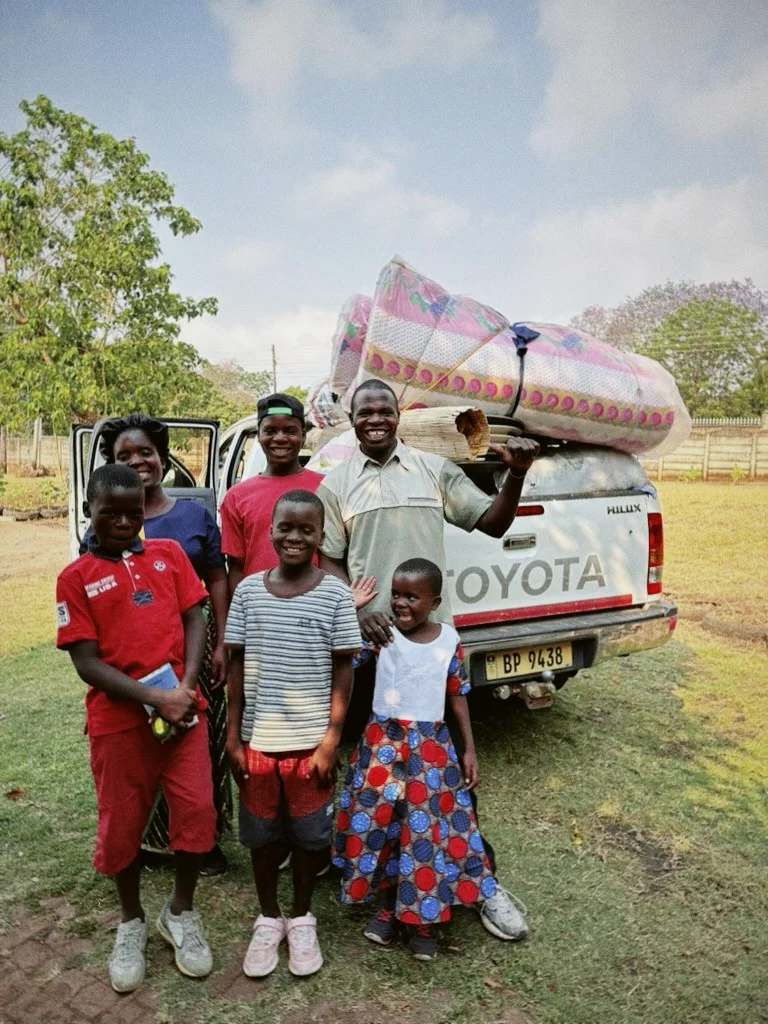 Família em frente a um carro de mudanças