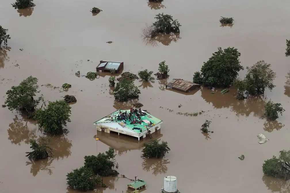 People take shelter on the roof of a house in an area completely flooded after Cyclone Idai passed through the city of Beira, Mozambique.